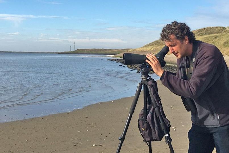 Vincent Stork in actie. Op de achtergrond de Mokbaai, één van de belangrijke wadvogelgebieden op Texel.